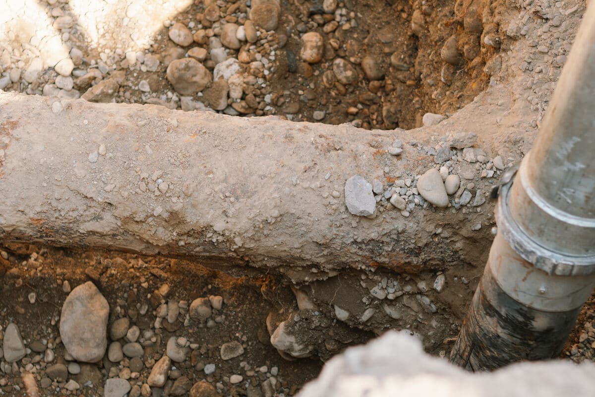 Gros plan sur la buse longeant une canalisation dégagée dans le terrain