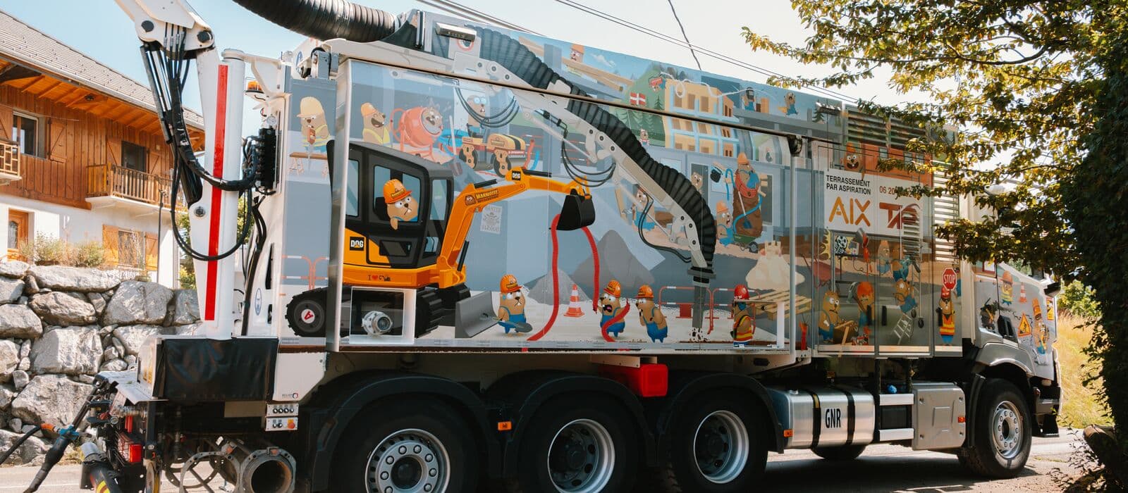 Camion aspiratrice-excavatrice AIX TP de profil, entièrement habillé de la fresque illustrée de marmottes de chantier