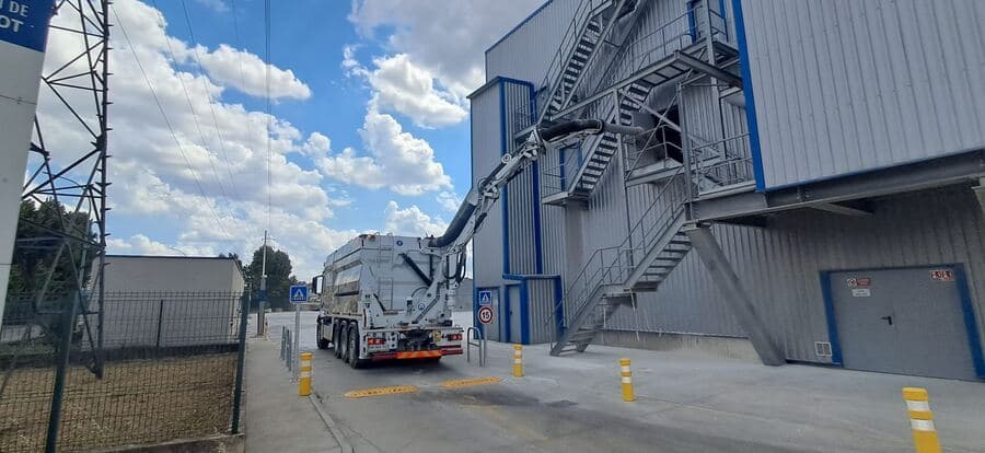 Camion aspirateur à poste devant un bâtiment industriel